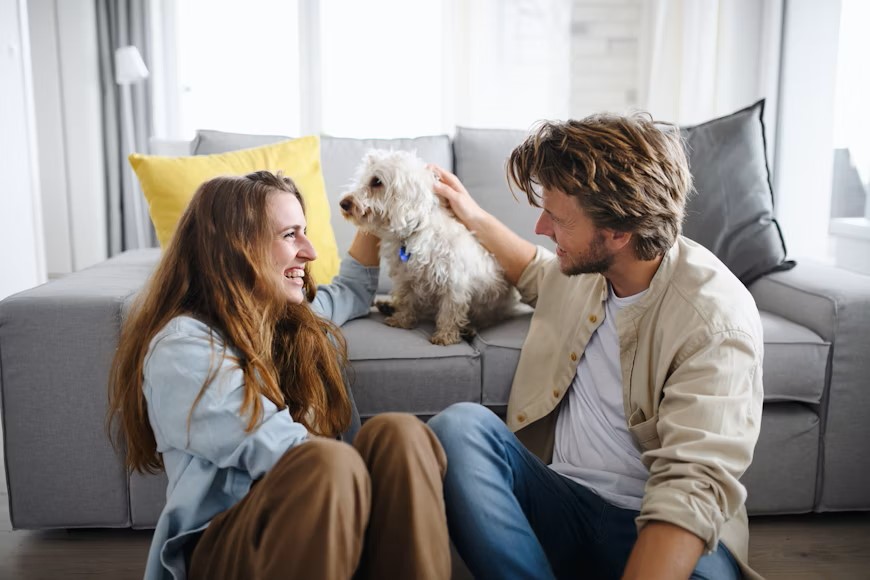 Couple relaxing together at home with their dog